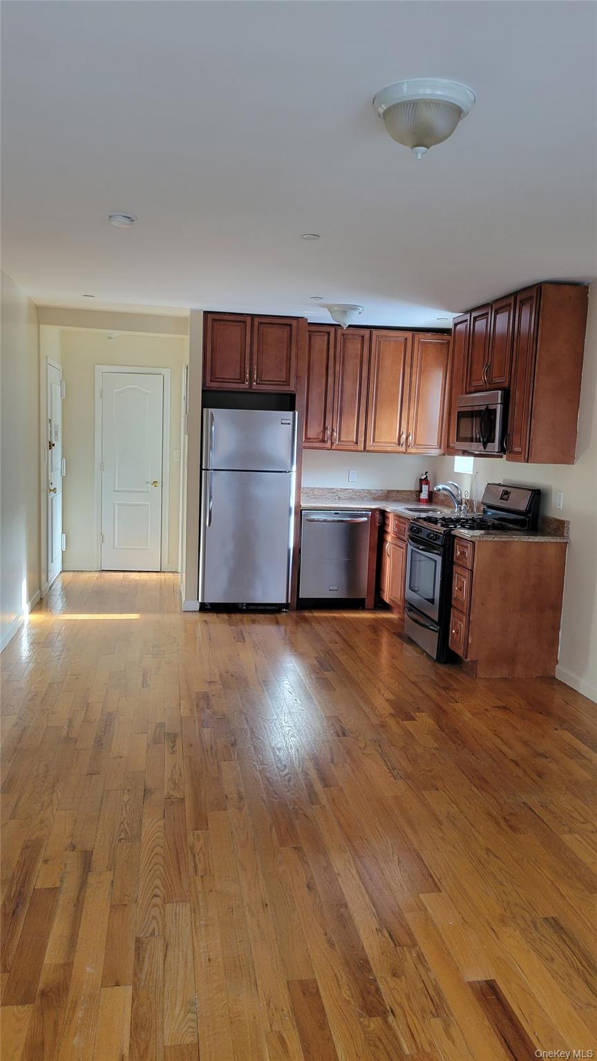 108-27 63rd Avenue, Unit 3B Queens, NY 11375 - Photo 7 of 17 a view of kitchen and empty room with wooden floor