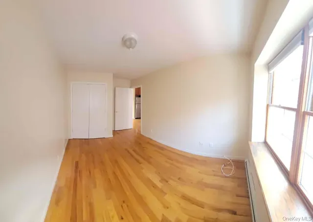 a view of a big room with wooden floor and windows