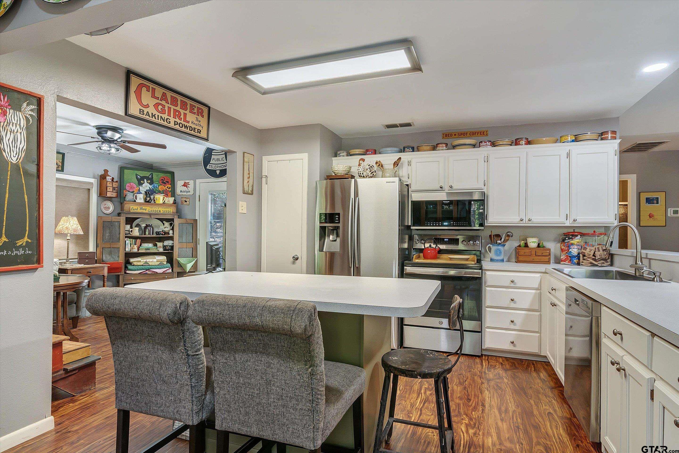 210 Magnolia Lane Holly Lake Ranch, TX 75765 - Photo 24 of 42 a kitchen with a table chairs refrigerator and microwave