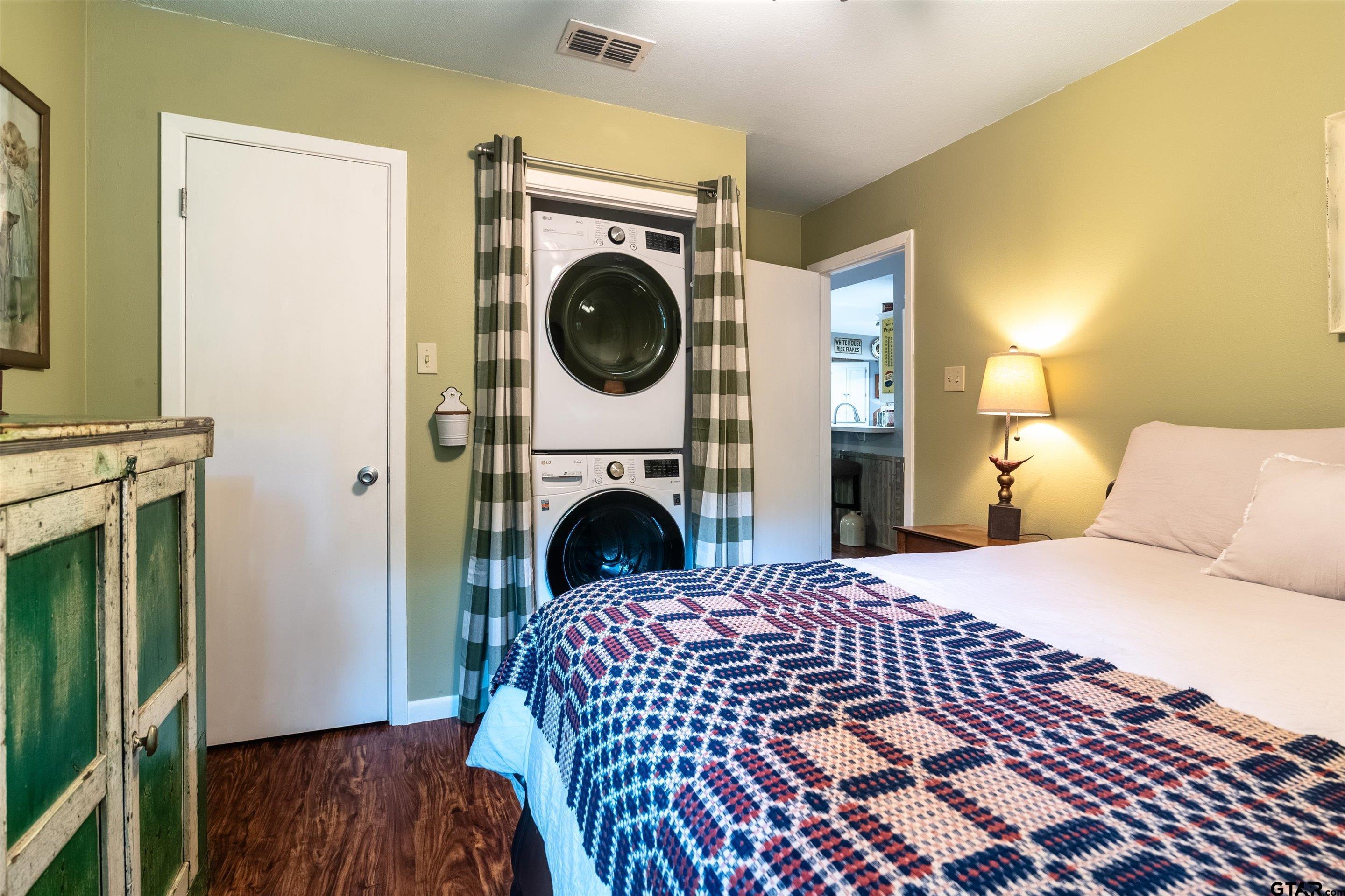 210 Magnolia Lane Holly Lake Ranch, TX 75765 - Photo 40 of 42 a bedroom with a bed and a washing machine with wooden floor