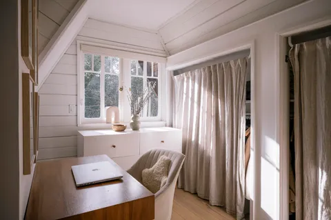 a view of a workspace with furniture and a window