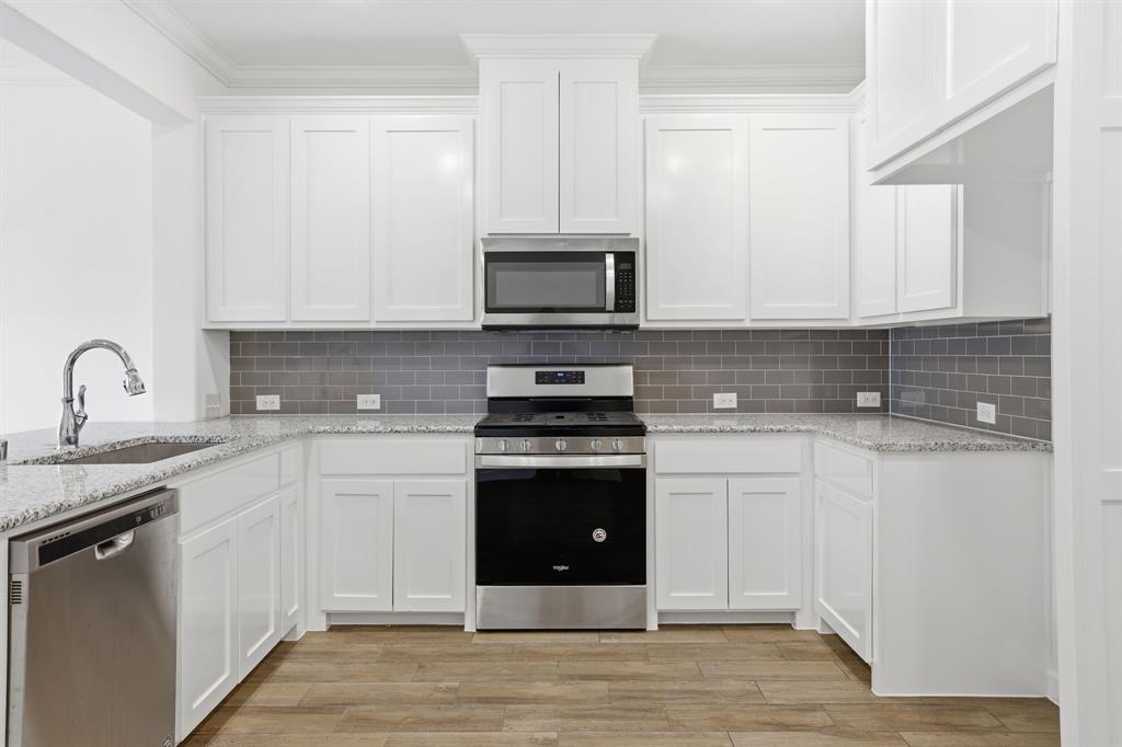 5832 Ridgeline Drive McKinney, TX 75070 - Photo 11 of 26 a kitchen with stainless steel appliances granite countertop a stove a sink and a microwave
