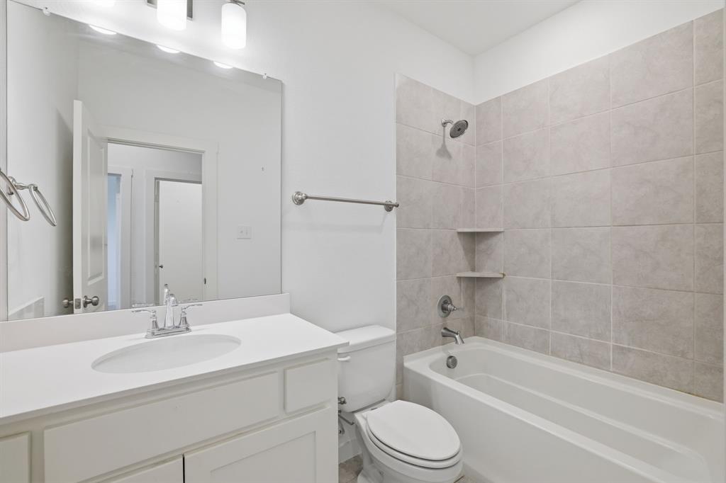 5832 Ridgeline Drive McKinney, TX 75070 - Photo 16 of 26 a bathroom with a bathtub shower sink vanity mirror and toilet