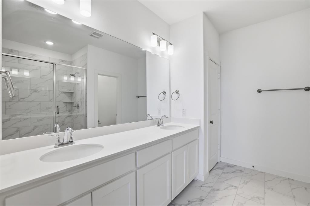 5832 Ridgeline Drive McKinney, TX 75070 - Photo 23 of 26 a bathroom with a double vanity sink mirror and shower