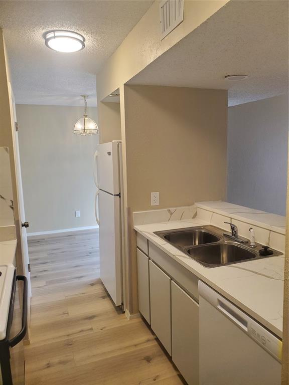 5532 Boca Raton Boulevard, Unit 290 Fort Worth, TX 76112 - Photo 6 of 16 Kitchen featuring light cabinetry, a double basin stainless steel sink, white countertops, and a white refrigerator