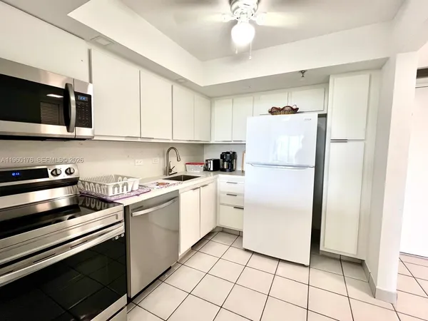 a kitchen with a refrigerator sink and cabinets