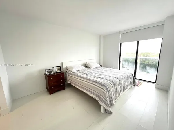 a bedroom with a bed and a large window