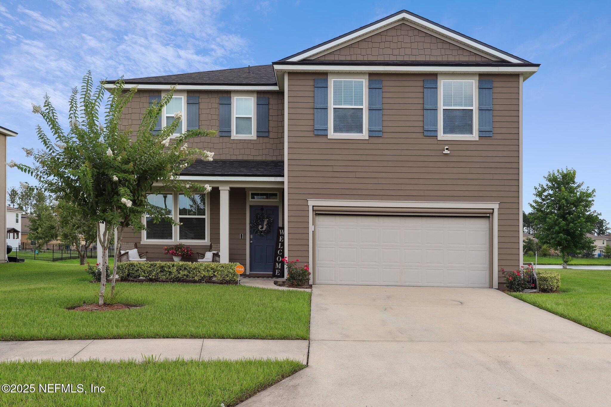 a front view of a house with a yard and garage