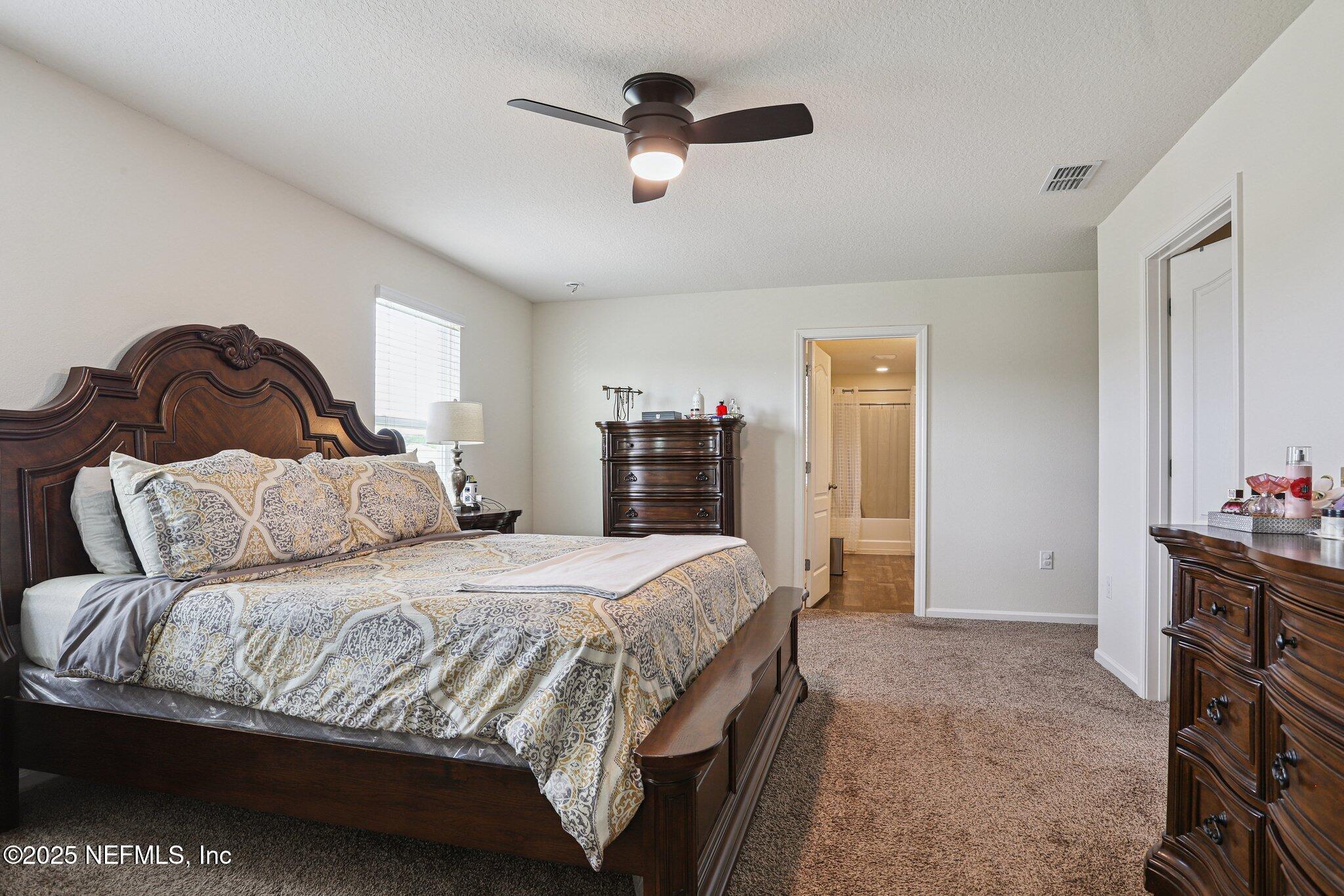 6829 Hanford Street Jacksonville, FL 32219 - Photo 15 of 24 a bedroom with a large bed and a ceiling fan
