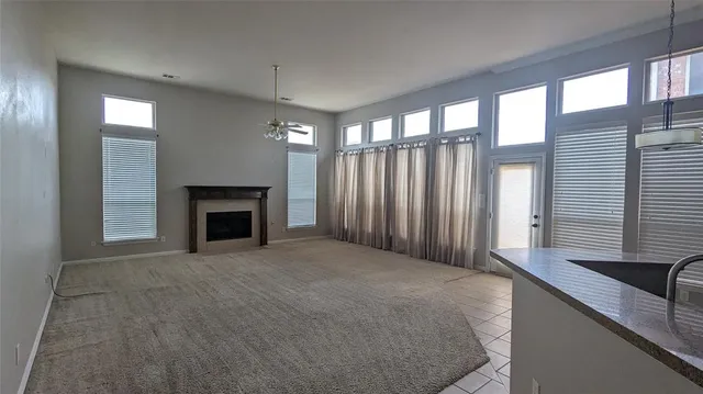 a view of an empty room with a fireplace and a window