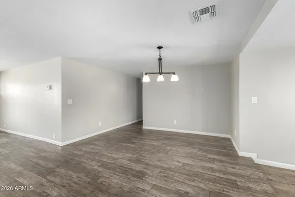 a view of an empty room with a chandelier fan