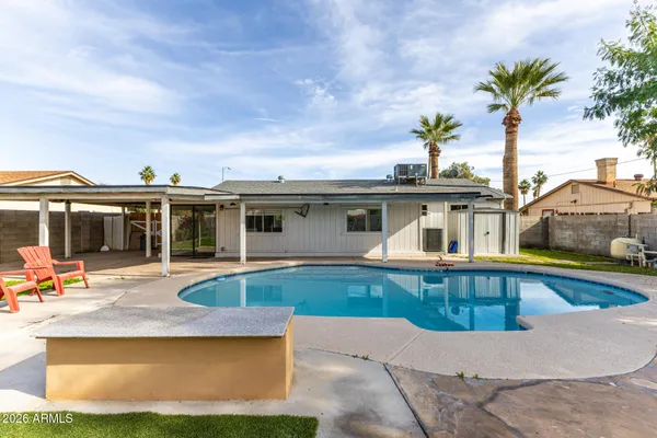a view of a house with swimming pool and sitting area