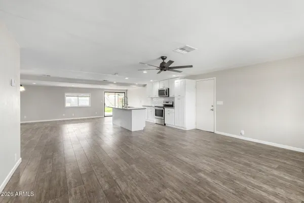 a view of empty room with wooden floor and window