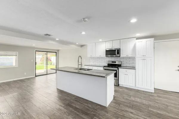 a kitchen with stainless steel appliances granite countertop a stove a sink and a refrigerator