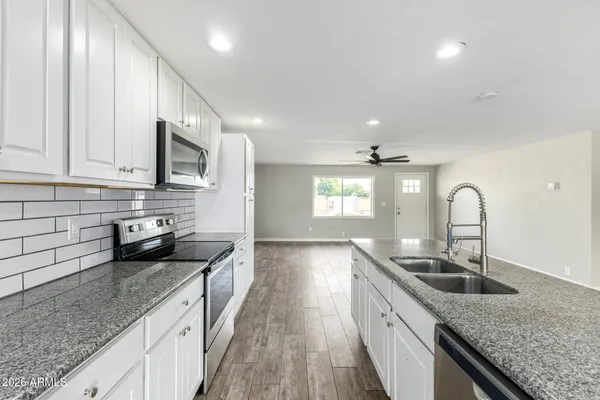 a kitchen with granite countertop a sink and cabinets