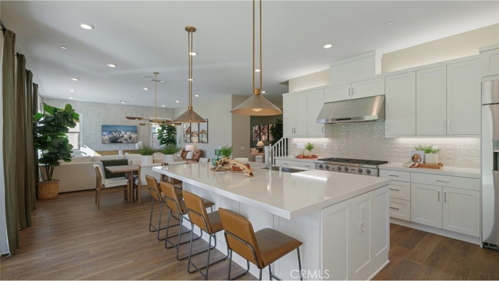 a large white kitchen with lots of counter space and stainless steel appliances
