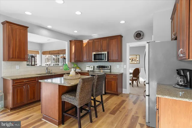a living room with furniture kitchen view and a wooden floor