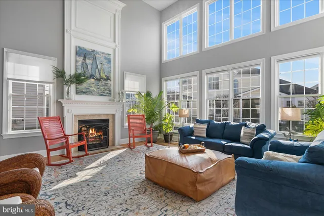 a living room with furniture fireplace and a large window