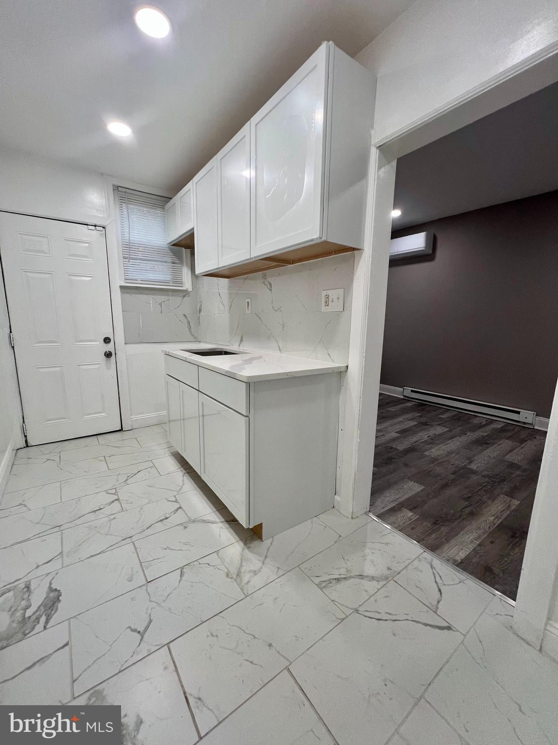 2610 Sylmar Street Philadelphia, PA 19142 - Photo 5 of 19 a kitchen with white cabinets and a refrigerator