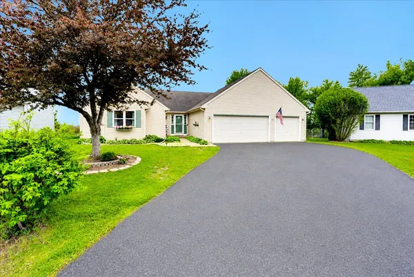 a view of a house with a yard and large tree