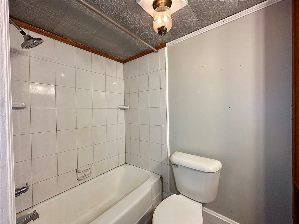 118 Firehall Road Portersville, PA 16051 - Photo 21 of 29 a white toilet sitting next to a bath tub and shower