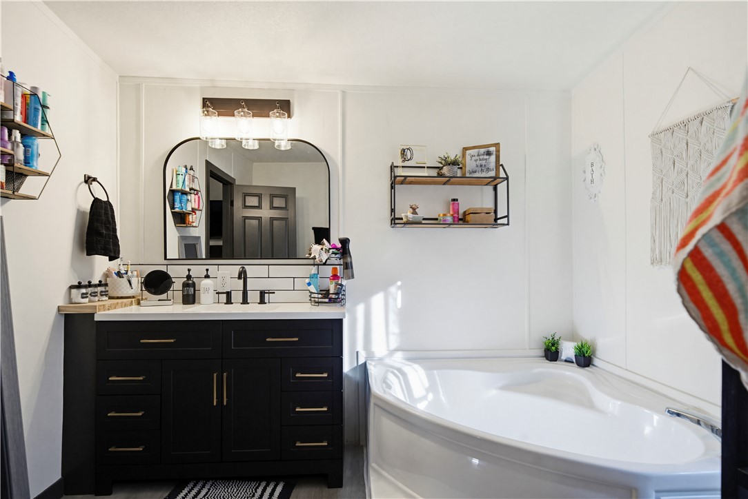 1071 South Estrella Road Golden Valley, AZ 86413 - Photo 30 of 50 a bathroom with a bathtub sink and mirror