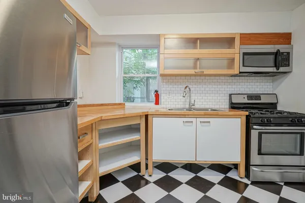 a kitchen with a stove a sink and a window