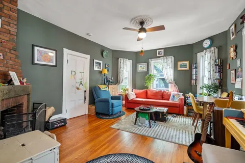 a living room with furniture a wooden floor and a window