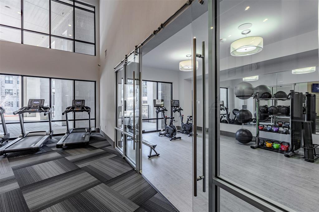 2700 Old Denton Road, Unit 1044 Carrollton, TX 75007 - Photo 28 of 33 Fitness center featuring full-height windows, patterned carpet flooring, and a glass barn door entry