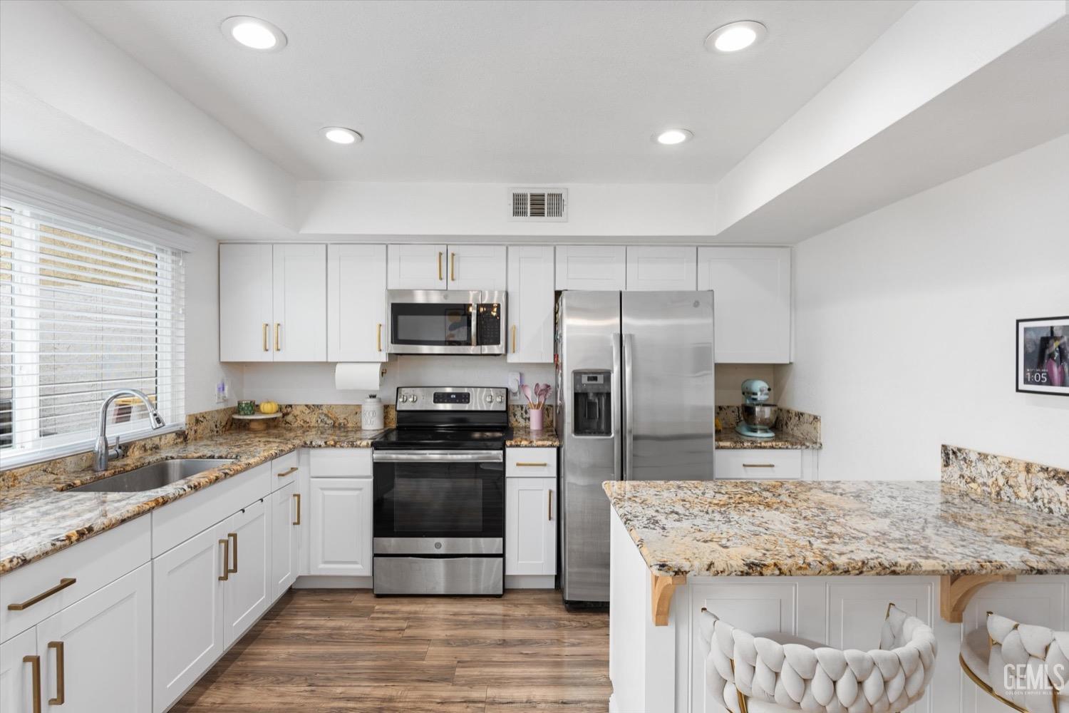 Undisclosed Address Bakersfield, CA 93308 - Photo 5 of 40 a kitchen with granite countertop a sink stainless steel appliances and white cabinets