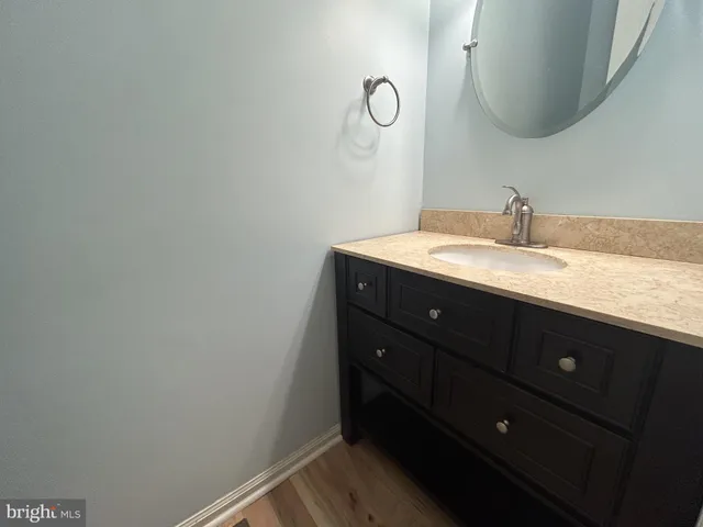a bathroom with a granite countertop sink and mirror