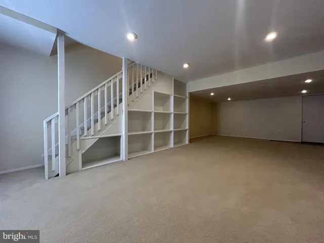 a view of an empty room with a cabinet and mirrors