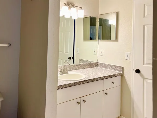 a bathroom with a granite countertop sink and a mirror