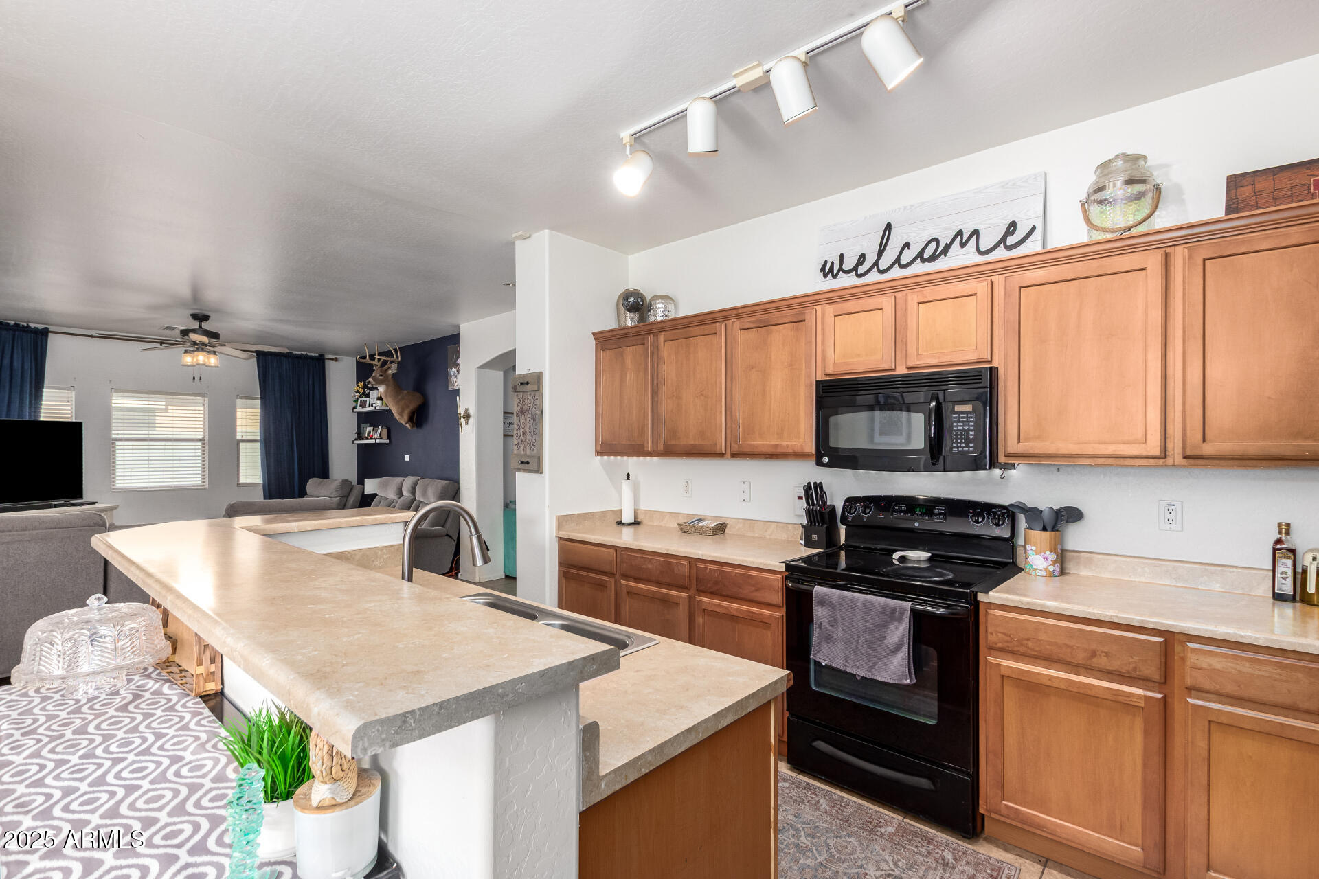 16947 West Cocopah Street Goodyear, AZ 85338 - Photo 11 of 22 a kitchen with granite countertop a sink a stove top oven a counter space and cabinets