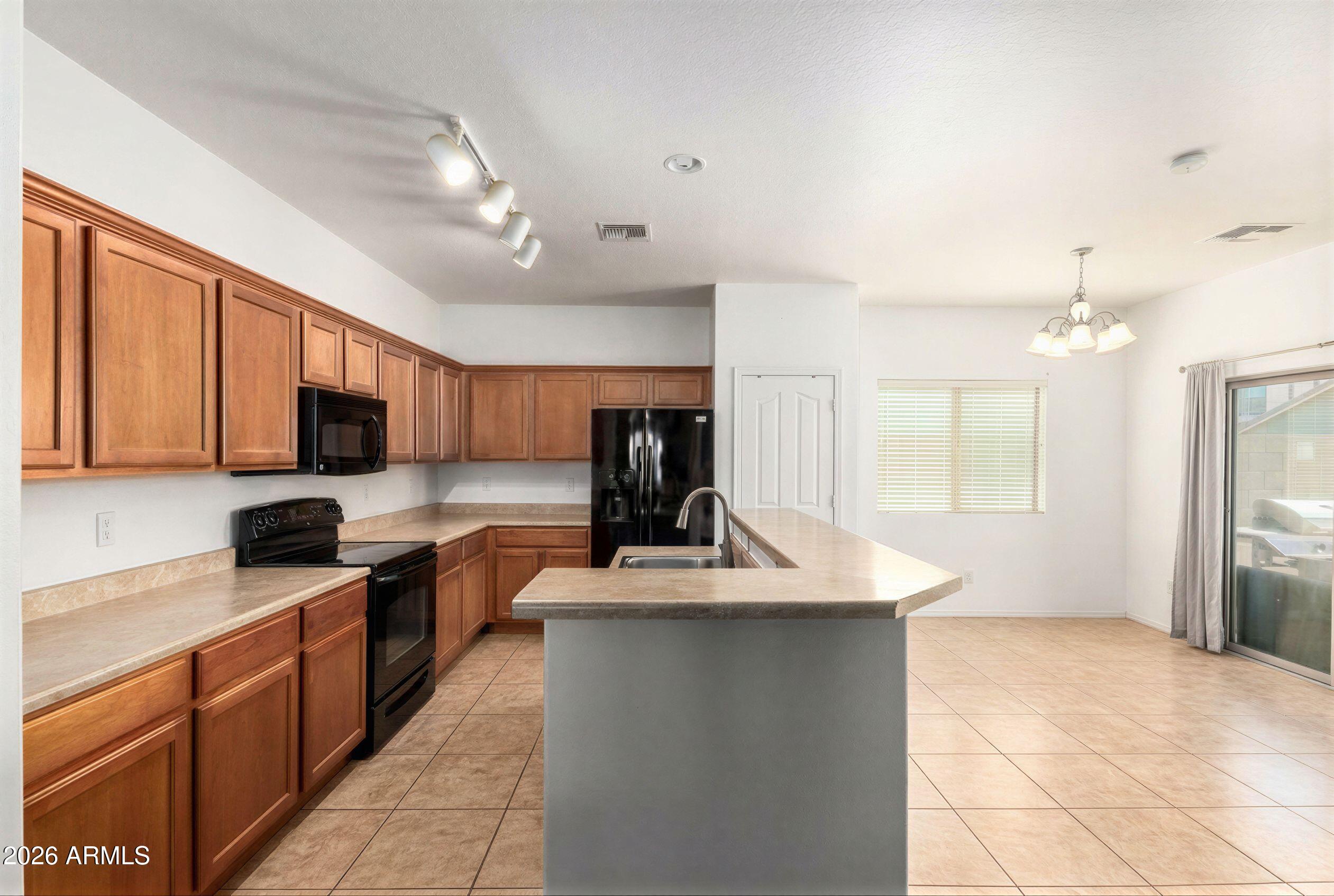 16947 West Cocopah Street Goodyear, AZ 85338 - Photo 4 of 22 a kitchen with kitchen island granite countertop a sink counter top space appliances and cabinets