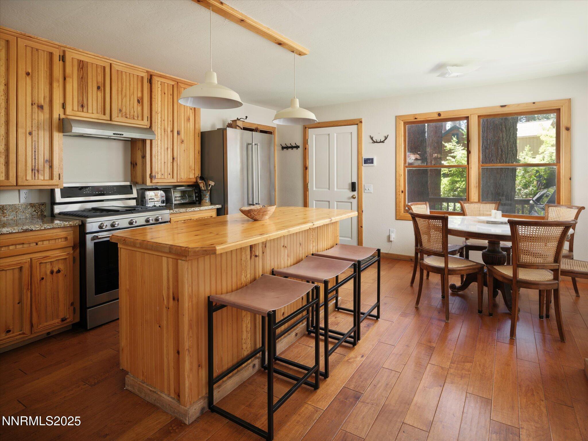644 Job Lane Zephyr Cove, NV 89448 - Photo 8 of 26 a dining hall with stainless steel appliances granite countertop a stove a refrigerator a dining table and chairs with wooden floor