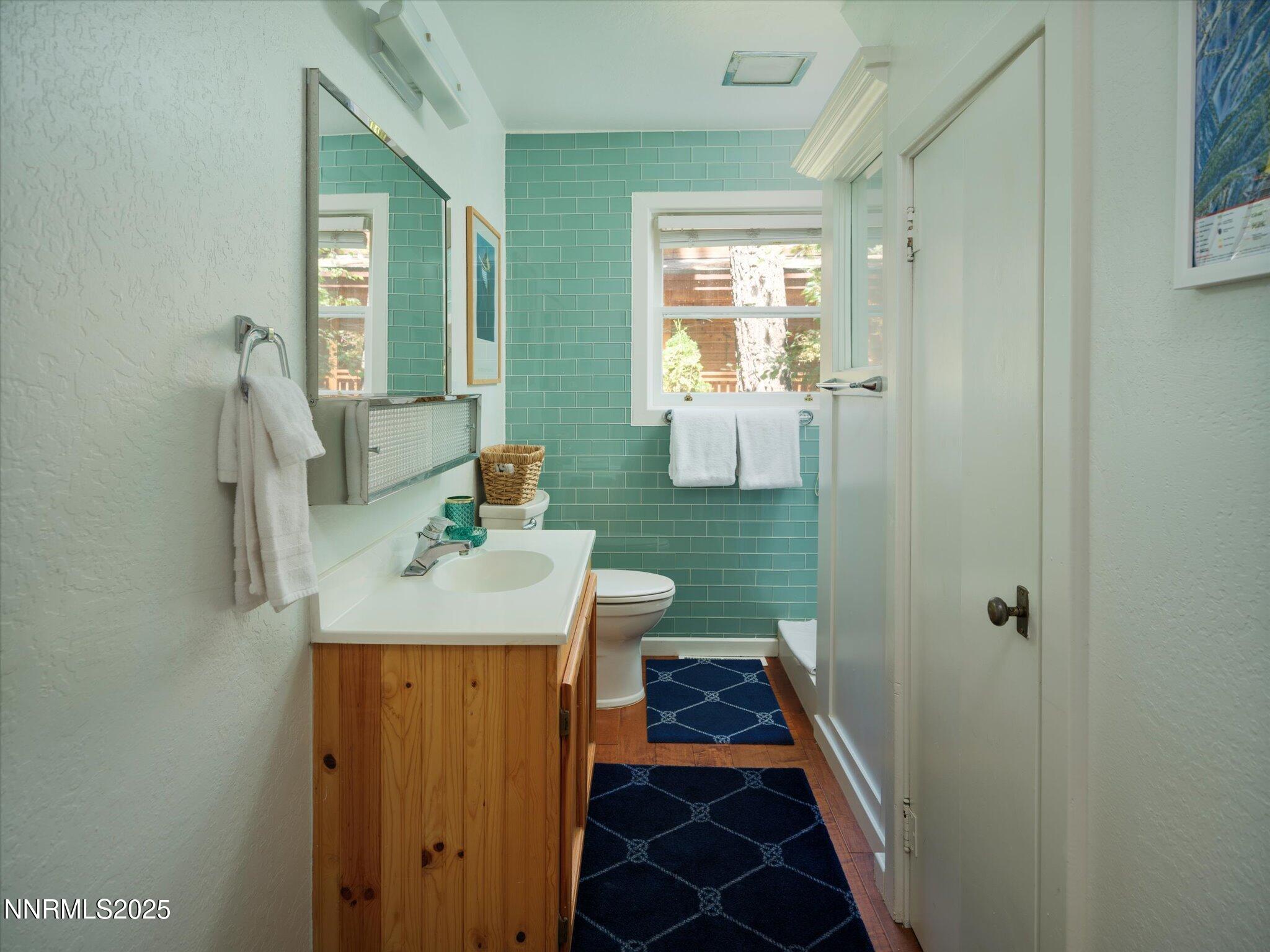 644 Job Lane Zephyr Cove, NV 89448 - Photo 10 of 26 a bathroom with a sink and mirror with toilet