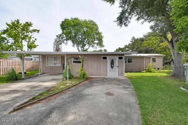 front view of a house with a yard and a trees