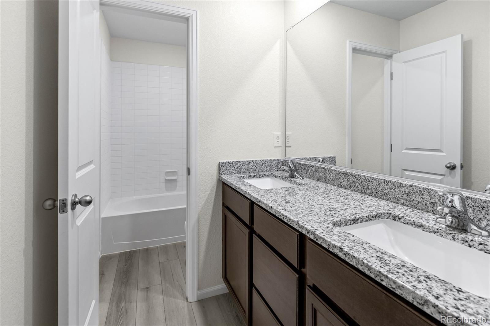 7003 Fall River Drive Frederick, CO 80530 - Photo 14 of 14 a bathroom with a granite countertop sink and a mirror