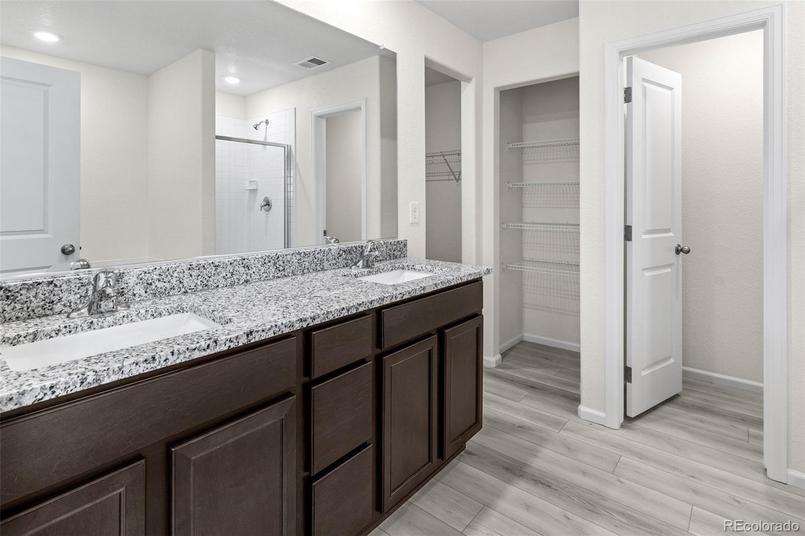 7003 Fall River Drive Frederick, CO 80530 - Photo 8 of 14 a bathroom with a granite countertop sink and a mirror