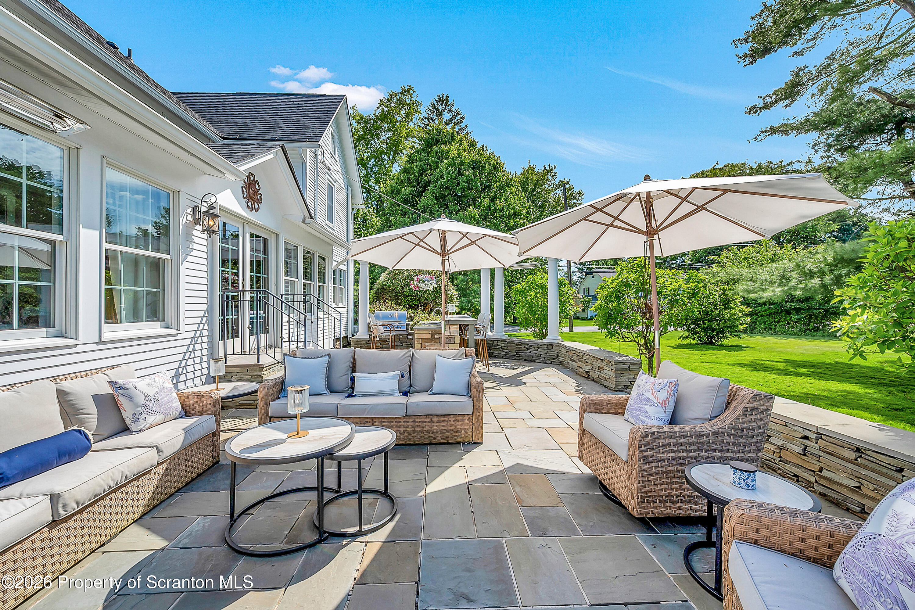 330 Glenburn Road Clarks Green, PA 18411 - Photo 9 of 69 a view of a patio with couches table and chairs under an umbrella with a fire pit