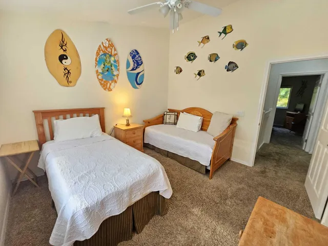 a bedroom with two beds and painting on the wall