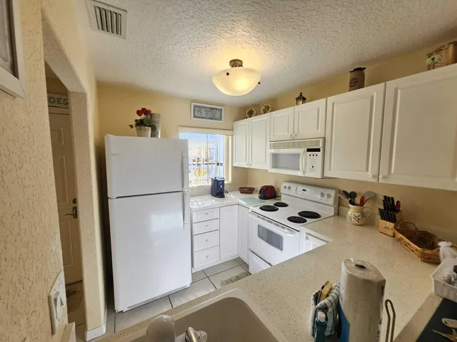 a kitchen with a refrigerator a stove top oven a sink and cabinets