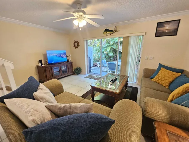 a living room with furniture a flat screen tv and a large window