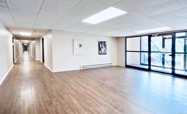 a view of a big room with wooden floor and windows