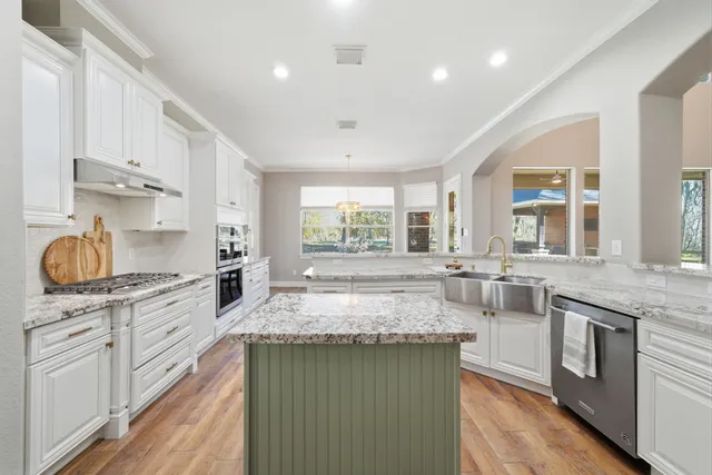 a large kitchen with kitchen island a sink and a stove top oven