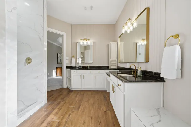 a bathroom with a granite countertop sink mirror and bathtub