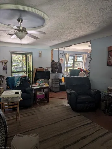 a kitchen with kitchen island a sink stove and view of living room