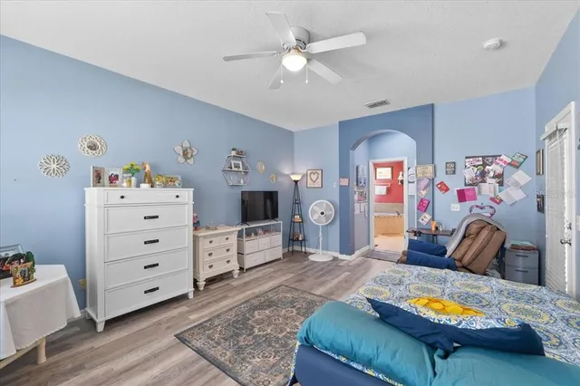 a bedroom with a bed and a flat tv screen on dresser