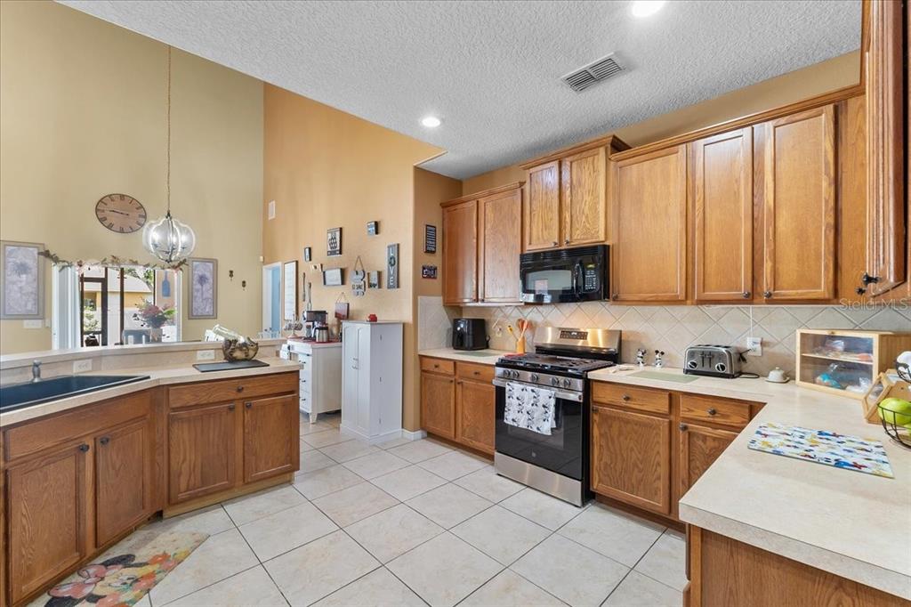 817 James Way Lake Alfred, FL 33850 - Photo 6 of 69 a kitchen with stainless steel appliances granite countertop a stove a sink dishwasher and a microwave oven with white cabinets